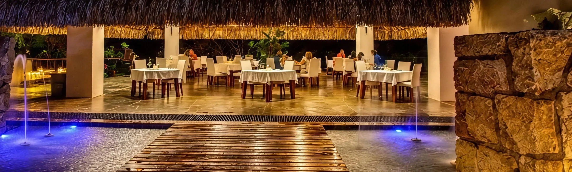 Restaurante bajo cubierta de palma iluminado de noche